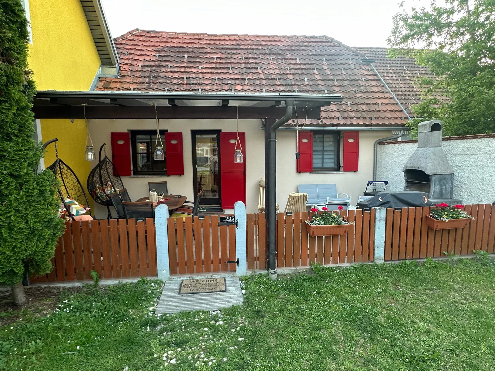 Zunanjost hiške s pokrito teraso in zasebno zelenico