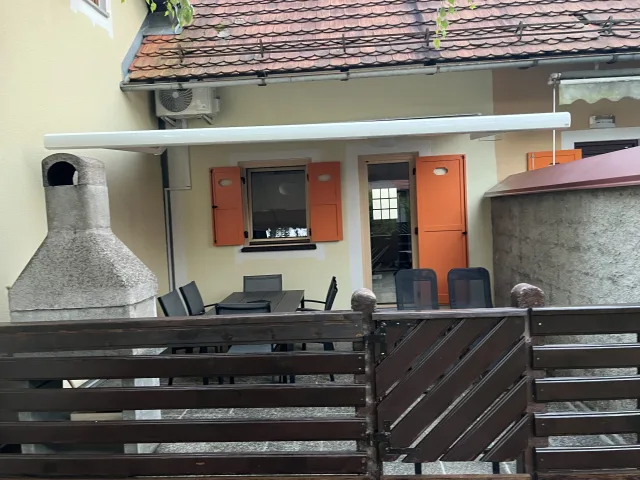 Pokrita terasa z zidanim žarom pred hiško